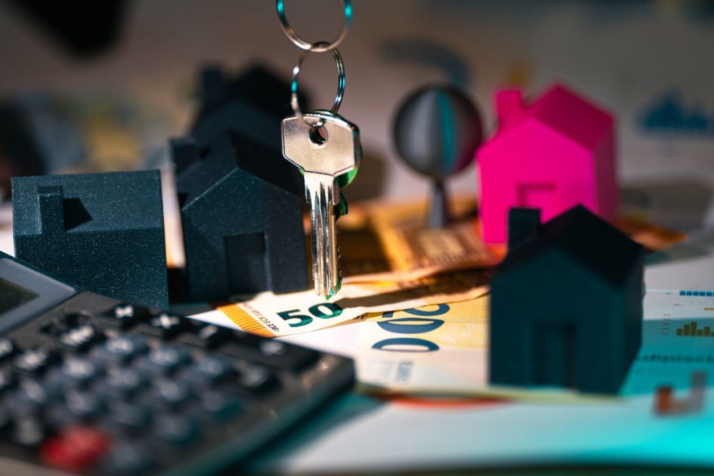 Clés et maisons miniatures posées sur un bureau