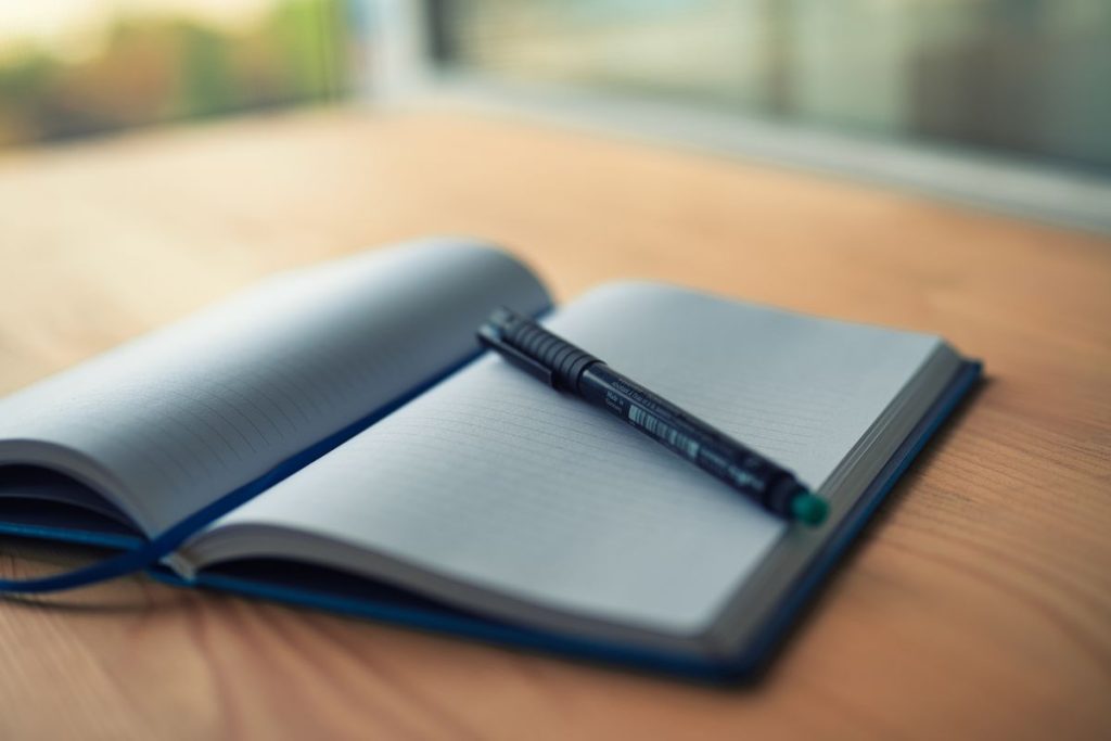 Cahier ouvert et stylo pour rédiger un brief