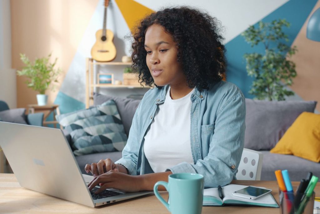 Femme travaillant à distance sur un ordinateur portable depuis son bureau